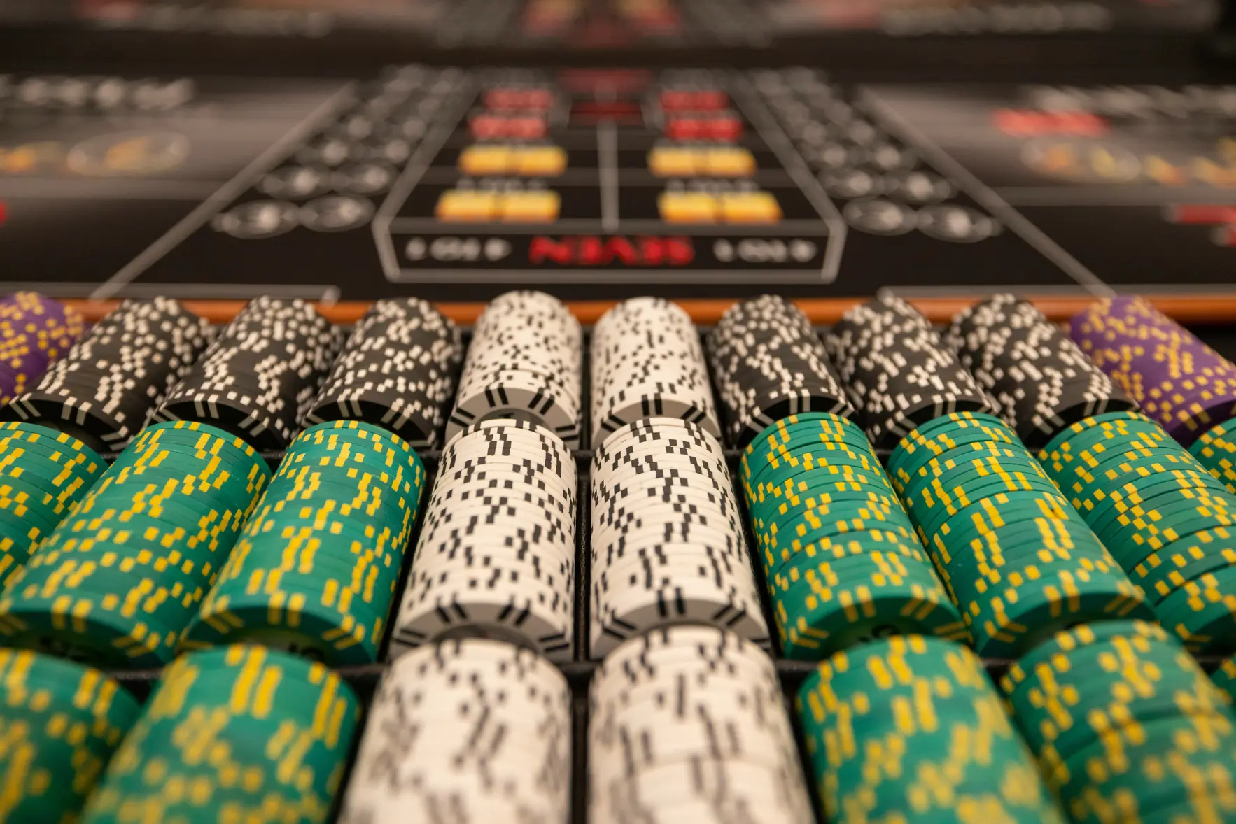 Grønne og hvite casinosjetonger på spillebord